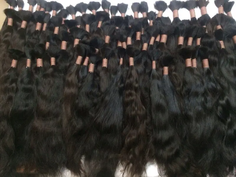 A large lot of black wavy bulk hair bundles, tied at the root